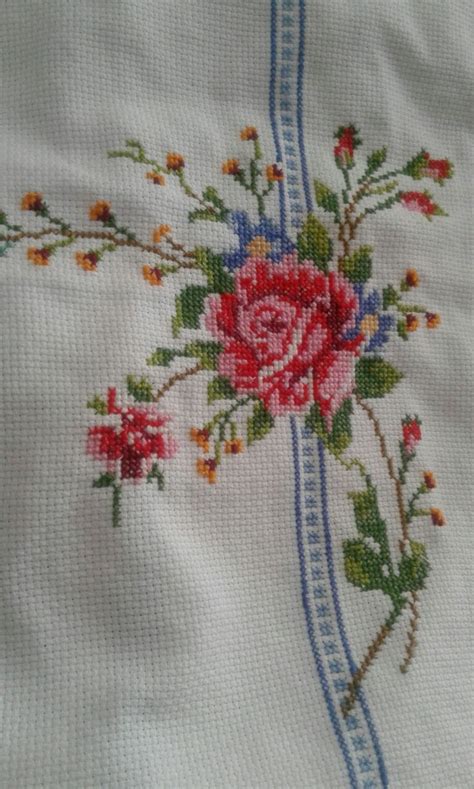 An Embroidered Piece Of Cloth With Flowers On It