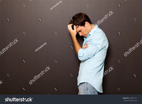 Thoughtful Man Standing Against Black Background Stock Photo 158972711