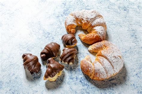 Dos Croissants Recién Horneados Con Azúcar De Vidrio Y Varios Mini Croissants De Chocolate Sobre