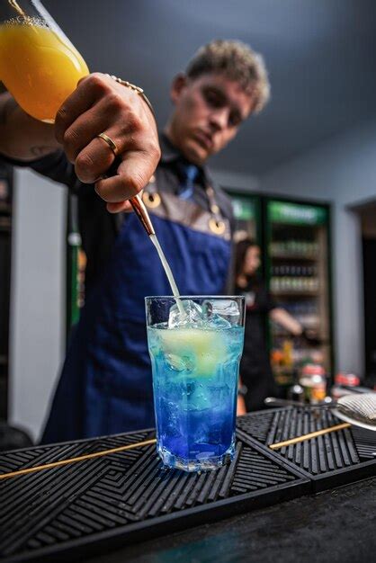 Barman profesional haciendo cócteles en el mostrador del bar detalles