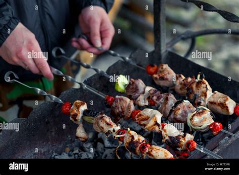 Male Hand With Shish Kebab Skewers On The Grill Close Up Stock Photo