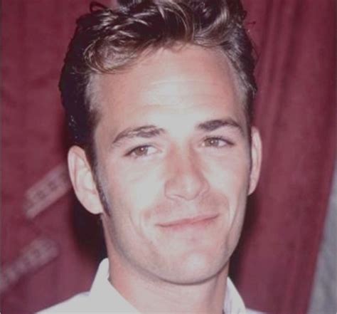 A Man In A White Shirt And Tie Smiling At The Camera With Red Curtains