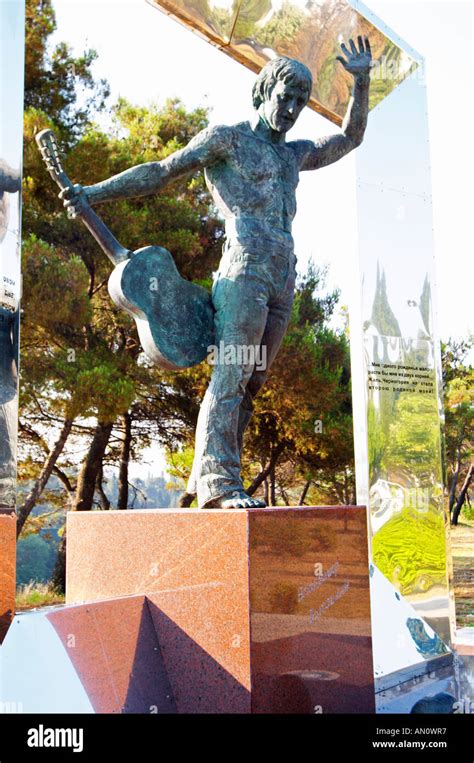 A modern statue of a musician with a guitar, framed by a silver square ...