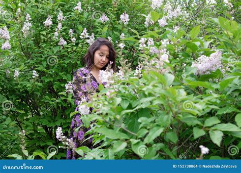 Portrait Of Beautiful Young Woman In Black Purple Dress In A Garden