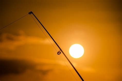 Silueta De Ca A De Pescar De Pescador Al Atardecer Naranja Foto Premium