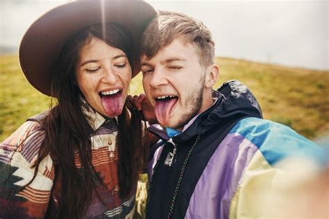 Feliz Pareja Hipster Haciendo Selfie Y Mostrando Lenguas De Colores De