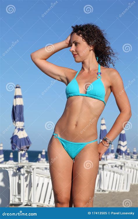 La Femme Dans Le Maillot De Bain Bleu Reste Sur La Plage Image Stock