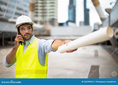 Caucasian Man Engineer Use A Smartphone For Talking Wearing Yellow