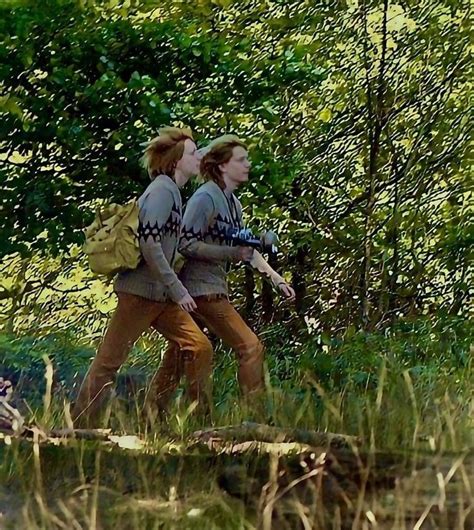 Two People Walking In The Woods With Backpacks