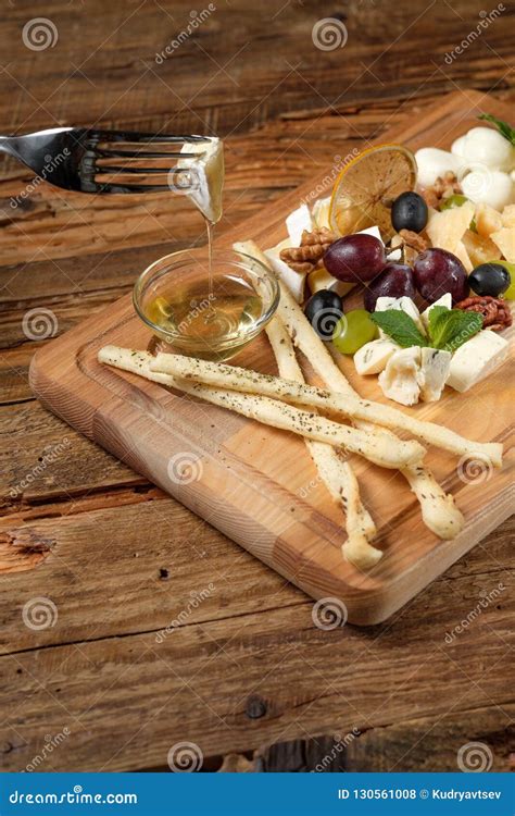 Piece of Cheese on Fork Above the Cheese Platter Stock Photo - Image of grapes, cutting: 130561008