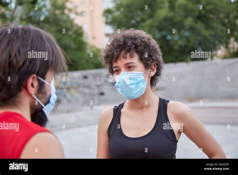 Two people having a conversation protected by face masks Stock Photo - Alamy