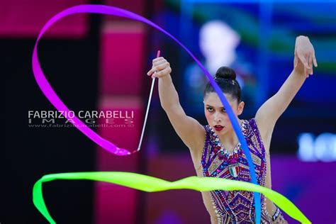 A Woman Is Performing With Colorful Streamers In Her Hand While Holding