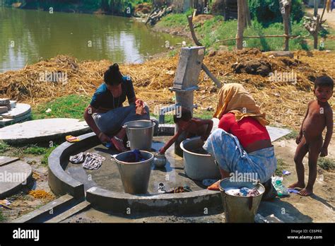 Indian Women Washing Clothes At Village Hand Pump Tharu Village