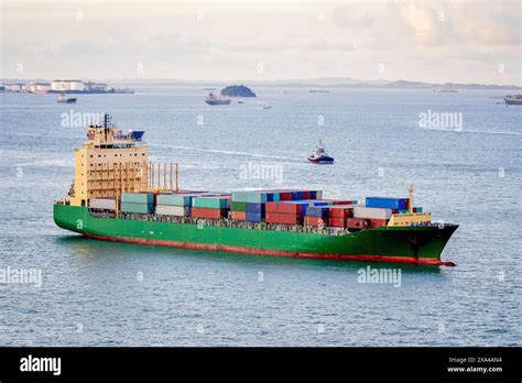 A Cargo Ship Loaded With Colorful Containers Sails Through A Vast Sea