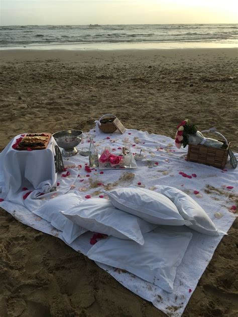 A Picnic Set Up On The Beach With Food And Drinks