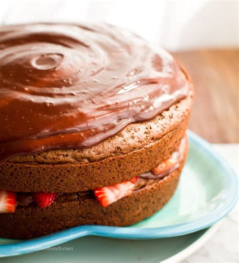 A Cake With Chocolate Frosting And Strawberries On A Blue Plate Ready To Be Eaten