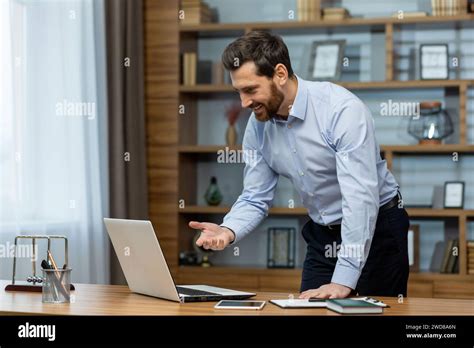 Smiling Mature Male Professional Engaging In Business Activities From A Well Organized Home