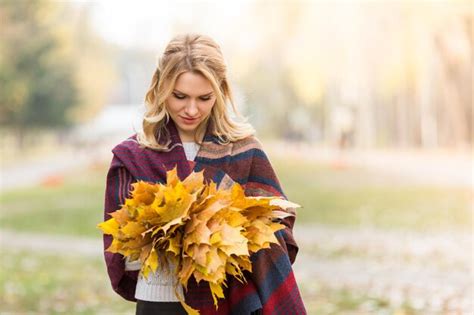 Une Blonde Souriante Offre Un Bouquet De Feuilles D Automne Jaunes Belle Dame En Plaid Chaud