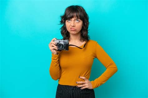 Mulher latina jovem fotógrafo isolada em fundo azul Foto Premium