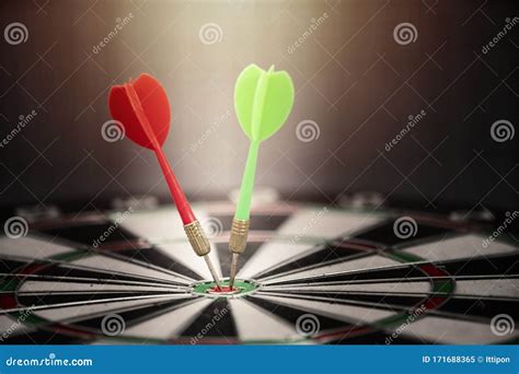 Close Up Red And Green Dart Arrow Hitting On Target Center Of Dartboard