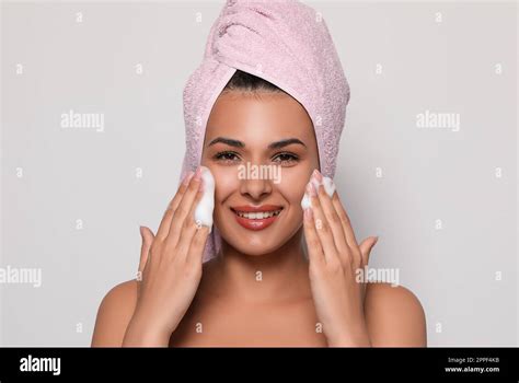 Beautiful Woman Applying Facial Cleansing Foam On White Background