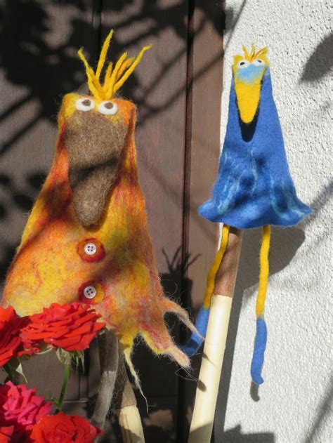 Two Stuffed Birds Sitting Next To Each Other On Top Of A Wooden Pole