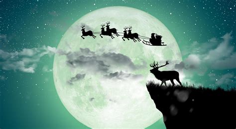 Silhouette Of Santa Claus Flying Over The Full Moon Stock