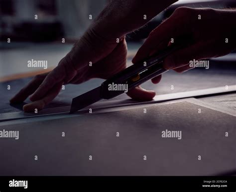 Craftsmanship cutting cardboard with paper knife Stock Photo - Alamy