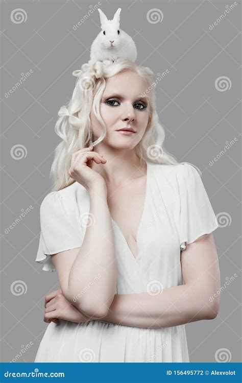 Jeune Fille Blonde Albinos En Robe élégante Posant Avec Un Petit Lapin Mignon Photo stock