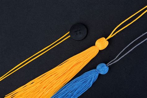 Premium Photo Close Up Black Graduation Cap And Yellow Blue Tassel