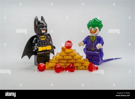 The LEGO figurines of Batman and Joker standing in front of a pile of ...