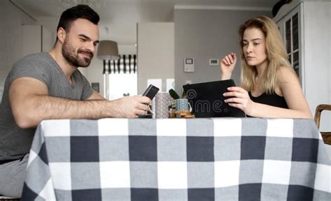 Pares Cariñosos Que Se Sientan En Una Tabla De Cocina Desayunando