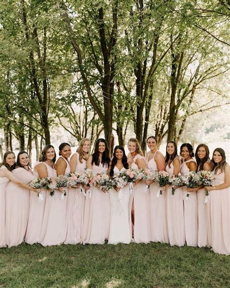 A Group Of Women Standing Next To Each Other In Front Of Trees With