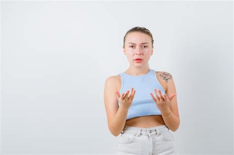 Blonde Dame öffnet ihre Handflächen auf weißem Hintergrund Kostenlose Foto