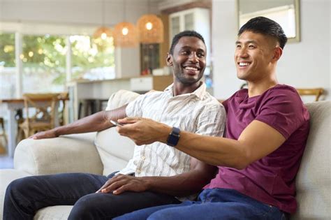 Same Sex Male Couple Or Friends On Sofa At Home Watching TV Together Stock Photo Image Of Film