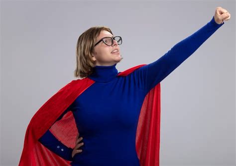 Confiant Jeune Femme De Super héros Blonde En Cape Rouge Portant Des Lunettes Debout Dans La