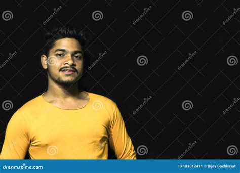 Young Man Model Wearing Yellow T Shirt With Black Isolated Dark