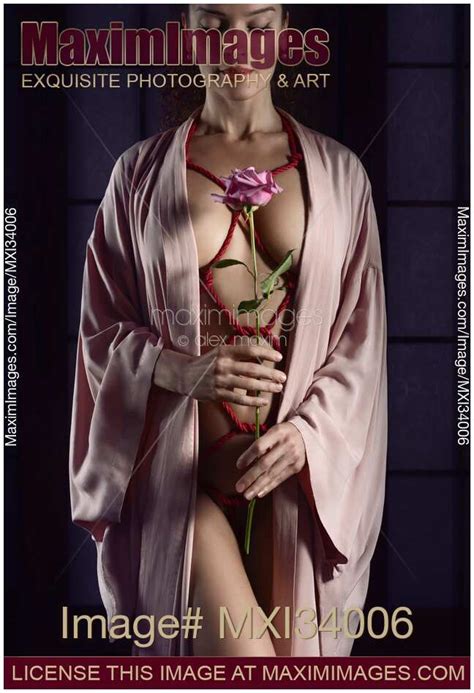 Photo Of Woman With Red Ropes Of Shibari Bondage Tied Around Her Sensual Naked Body Holding Pink