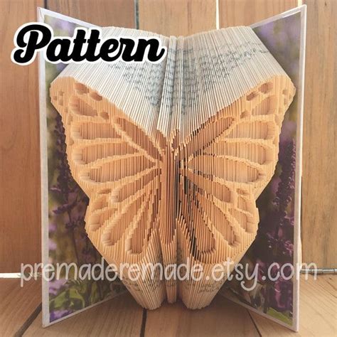 An Open Book With The Pages Folded To Look Like A Butterfly On Top Of It