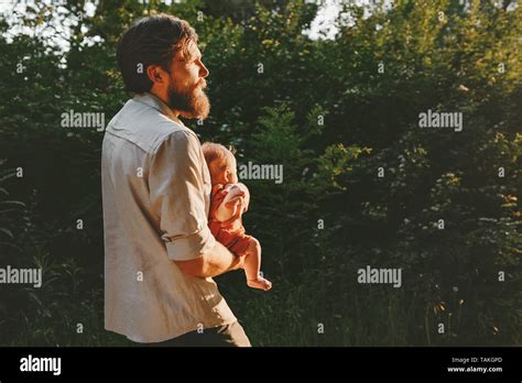 Father Holding Infant Baby Walking Together In Forest Outdoor Happy