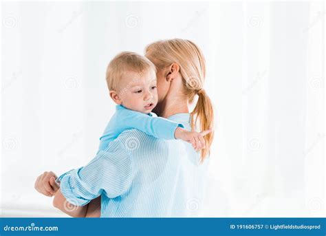 Vue De Femme Blonde Se Tenant Dans Le Fils Mignon D enfant En âge De Bras Pointée Du Doigt à La