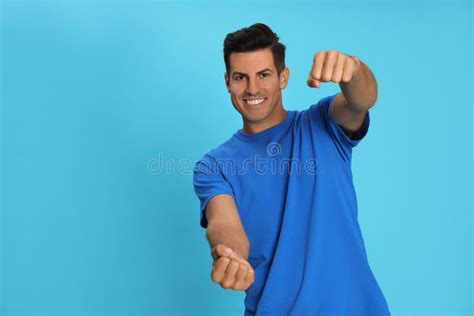 Happy Man Pretending To Drive Car On Light Blue Background Space For