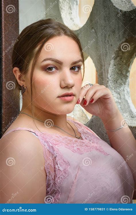 Brunette Flicka N Ra V Ggen Flickan I Rosa Skjortor Med L Ngt H R P Gatan Plusstorleksmodell