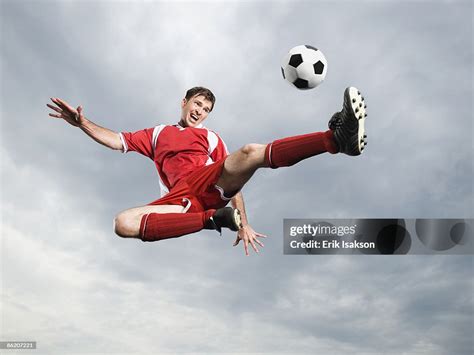 Soccer Player Kicking Soccer Ball In Midair High-Res Stock Photo ...