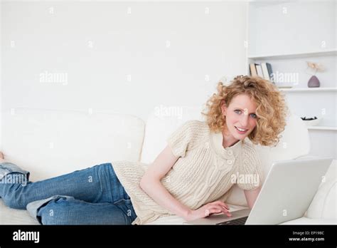 Charming Blonde Woman Relaxing With Her Laptop While Lying On A Sofa Stock Photo Alamy