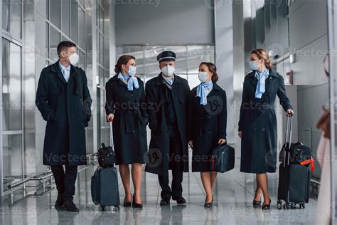 Aircraft Crew In Work Uniform Is Together Outdoors In The Airport