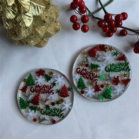 two christmas themed buttons sitting on top of a table