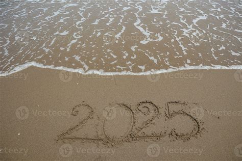 New Year Written In The Sand On A Beach With Sea Wave Background