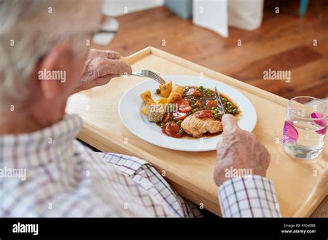 Over Shoulder View Of Senior Man Eating Dinner At Home Stock Photo Alamy