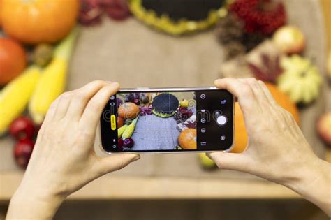 Hands Hold The Phone The Phone Photographs Pumpkins And Sunflowers On